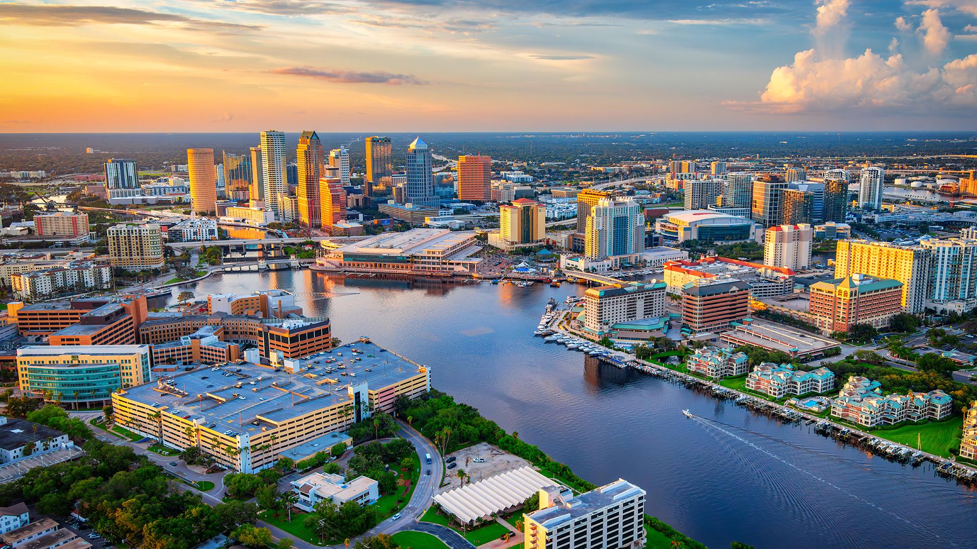 Vue aérienne de Tampa en Floride au coucher de soleil avec gratte-ciels et la rivière Hillsborough traversant la ville.