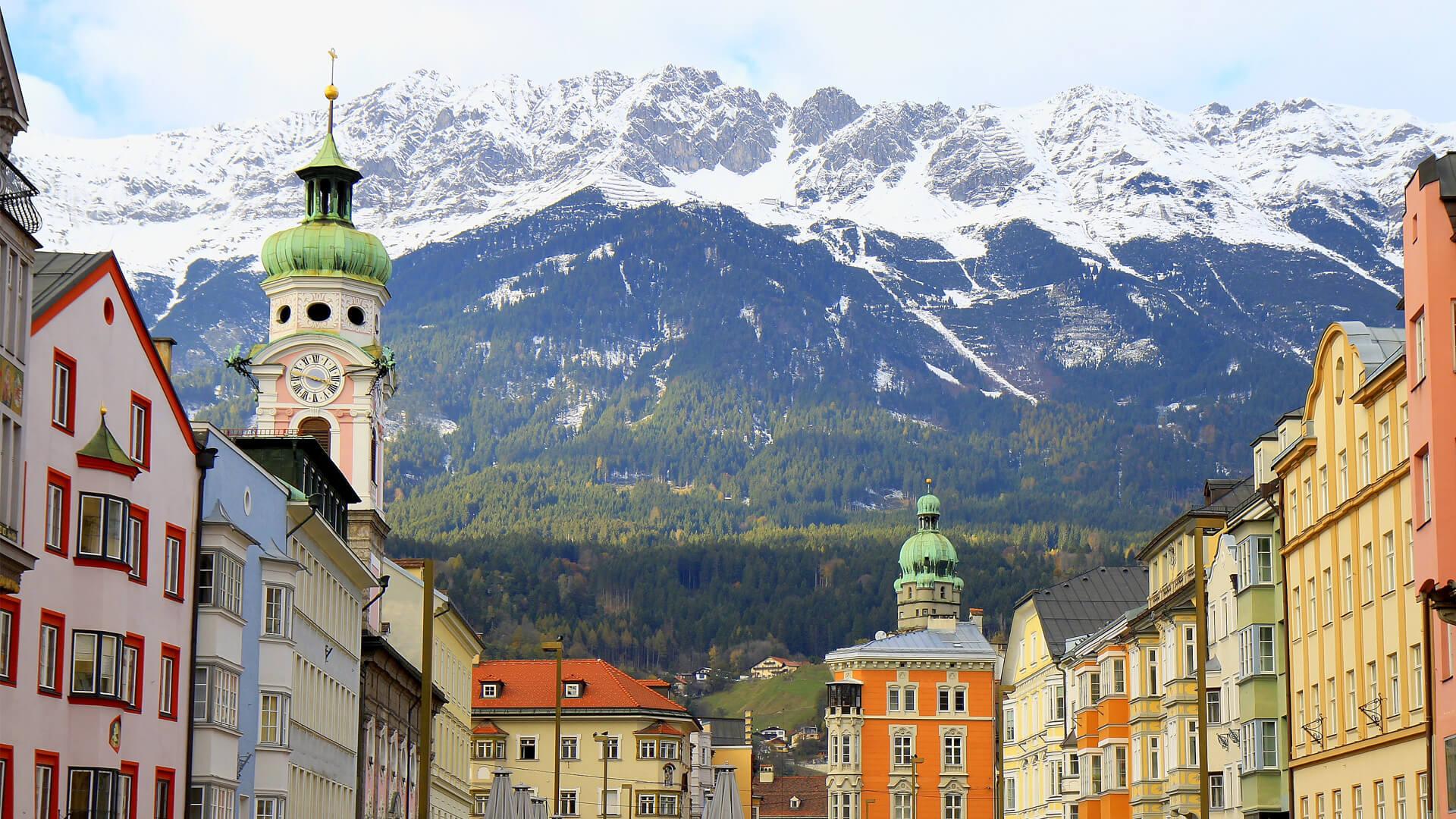 Colourful village of Innsbruck, Austria, with snow-capped Alps in the background, showcasing a typical Tyrolean panorama.