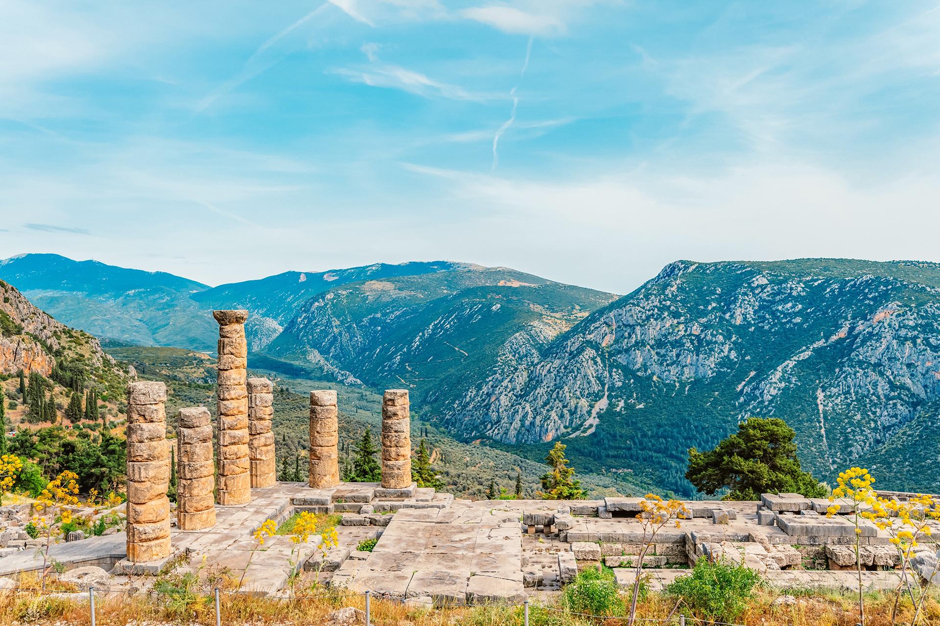 Panoramic view of the Temple of Apollo and its Doric columns in Delphi, Greece, perched on the slopes of Mount Parnassus.