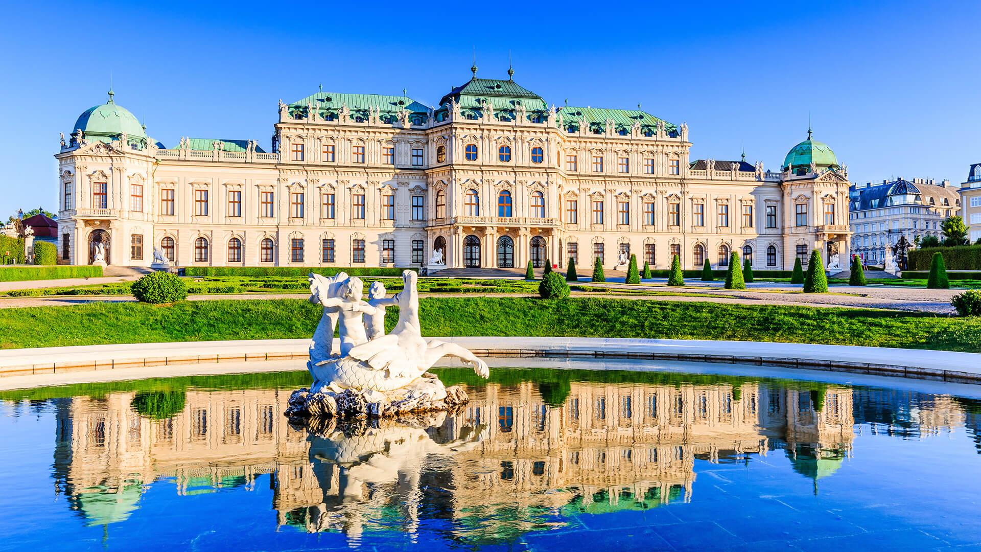Panoramic view of Belvedere Palace in Vienna, Austria, with its baroque architecture mirrored in the reflecting pool.