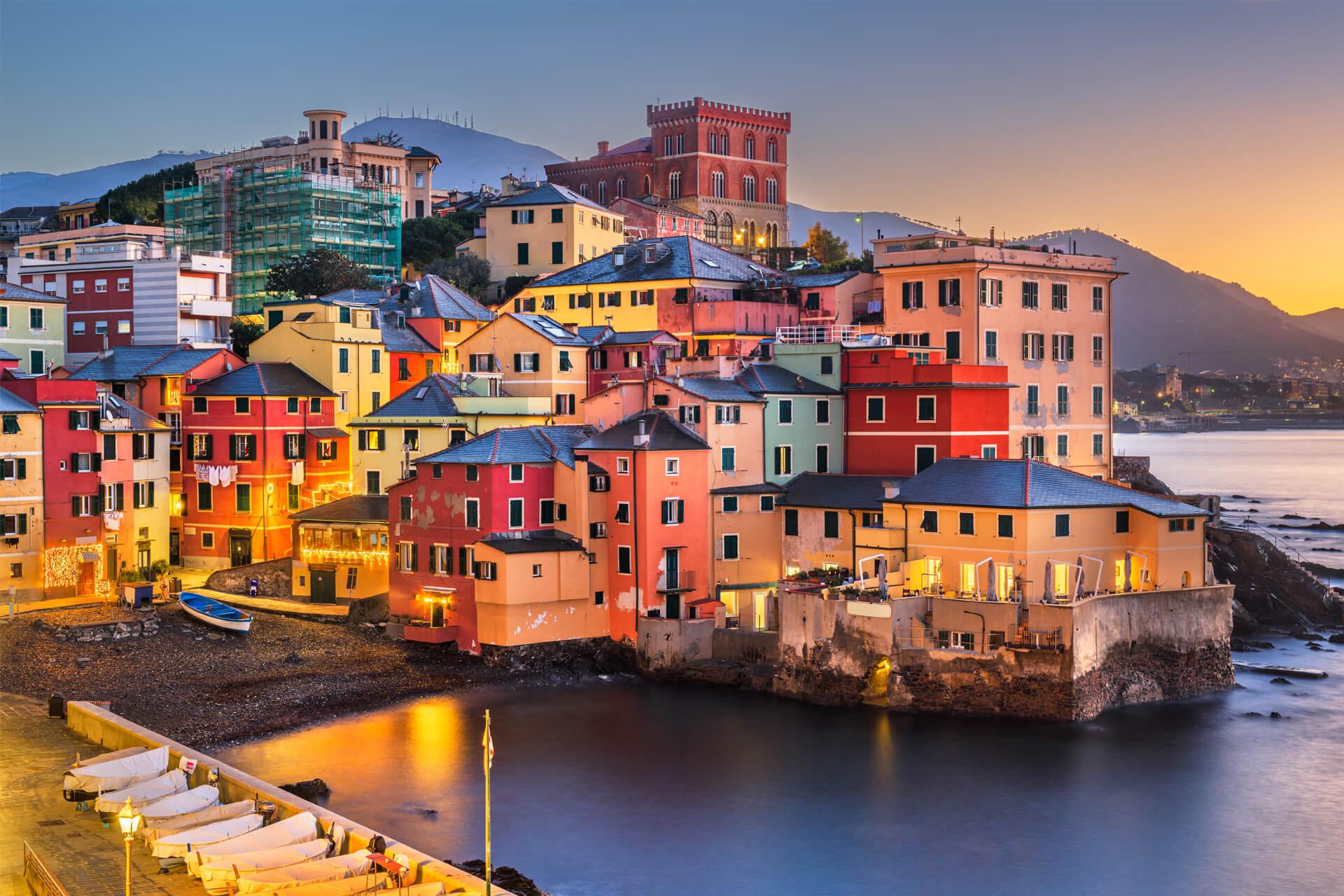 Colourful houses in the Boccadasse district of Genoa, Italy, overlooking the sea at sunset.