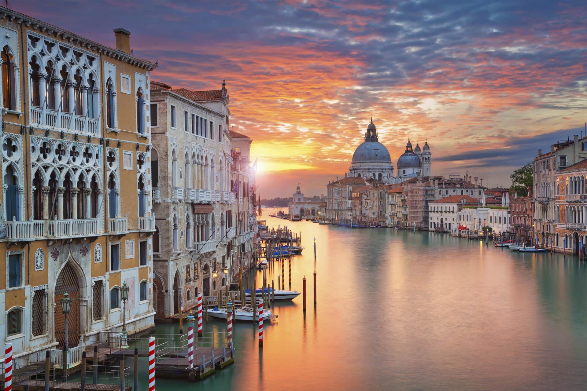Sunset over Venice’s Grand Canal, featuring Venetian palaces and Basilica di Santa Maria della Salute.
