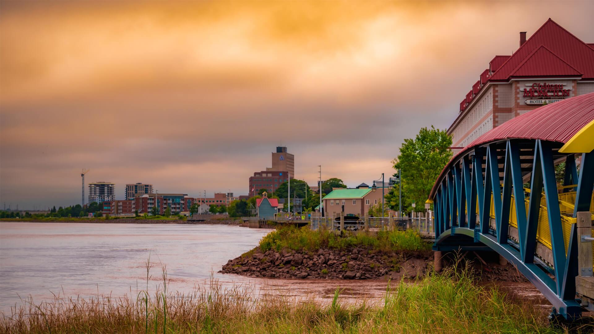 View of downtown Moncton in New Brunswick, with the bridge and waterfront at sunset.