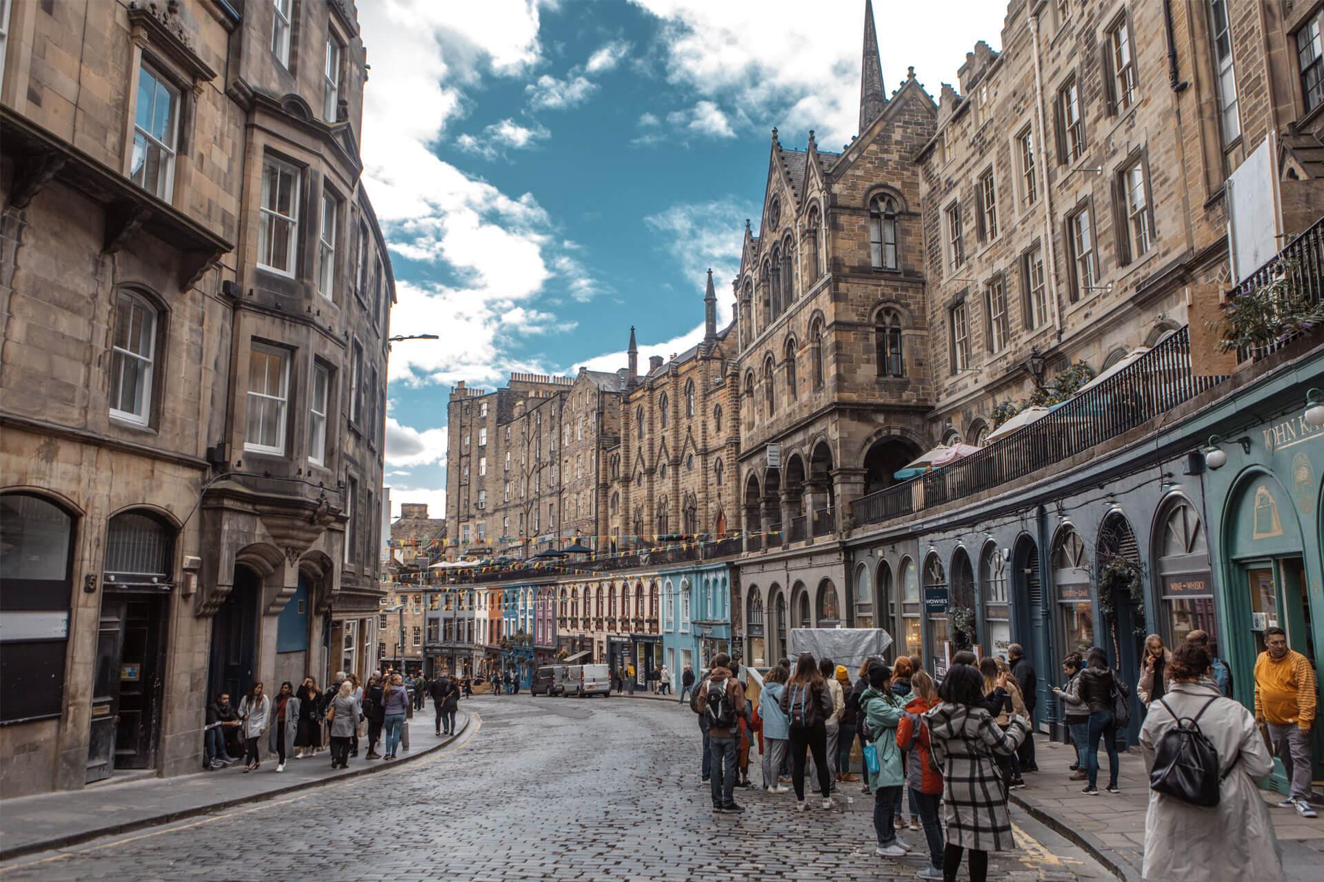Victoria Street in Edinburgh, Scotland, with historic stone buildings, colourful façades, and cobblestone pavement.