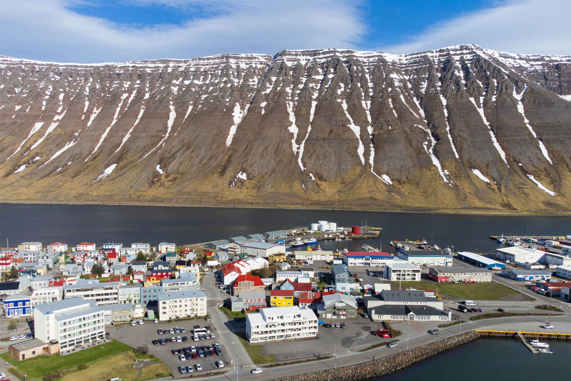 Vue aérienne d’Ísafjörður, petite ville de l’Islande, avec ses maisons colorées et entourée de montagnes abruptes et de fjords.