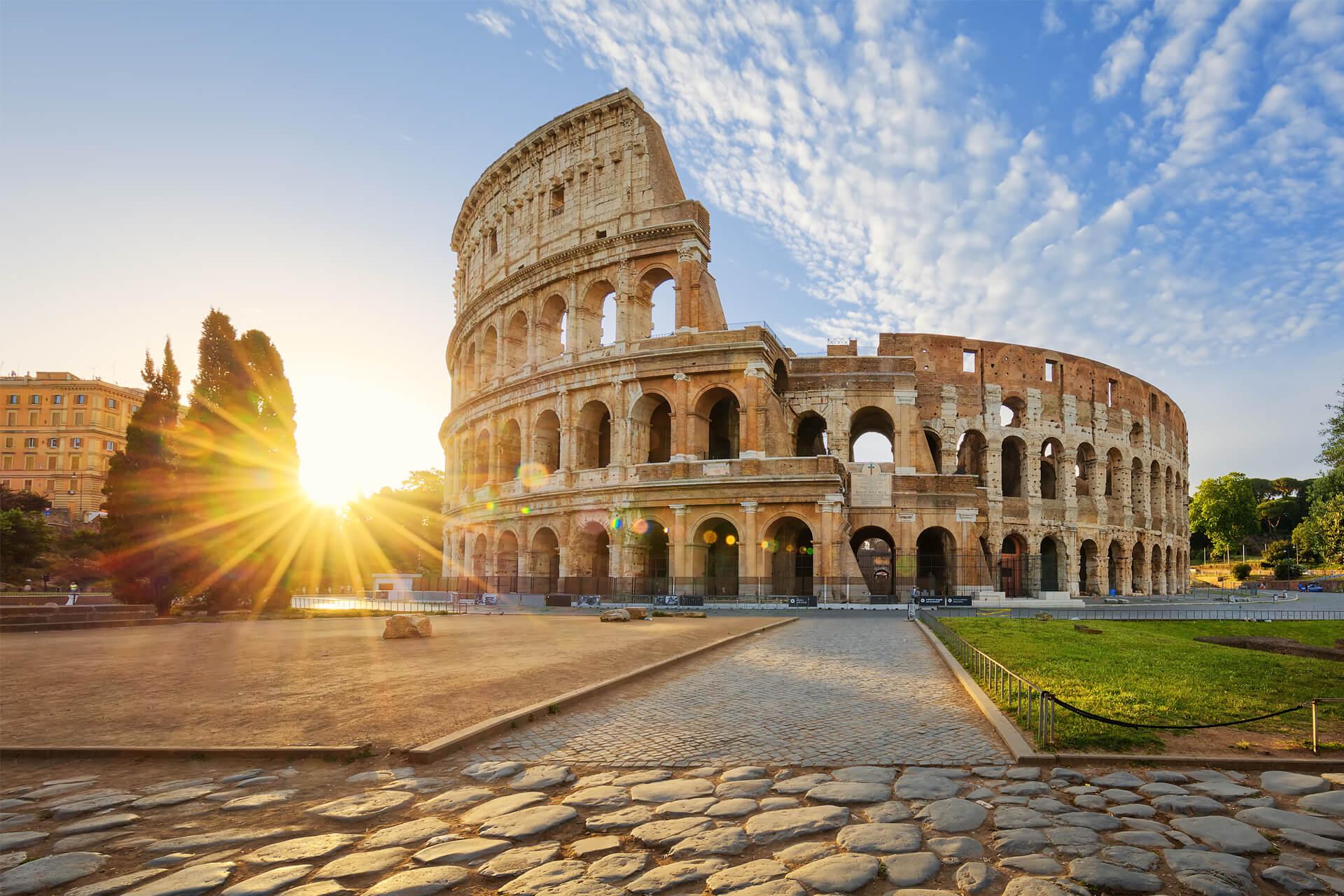 Rome’s Colosseum at sunrise, bathed in golden light and surrounded by ancient cobblestones.