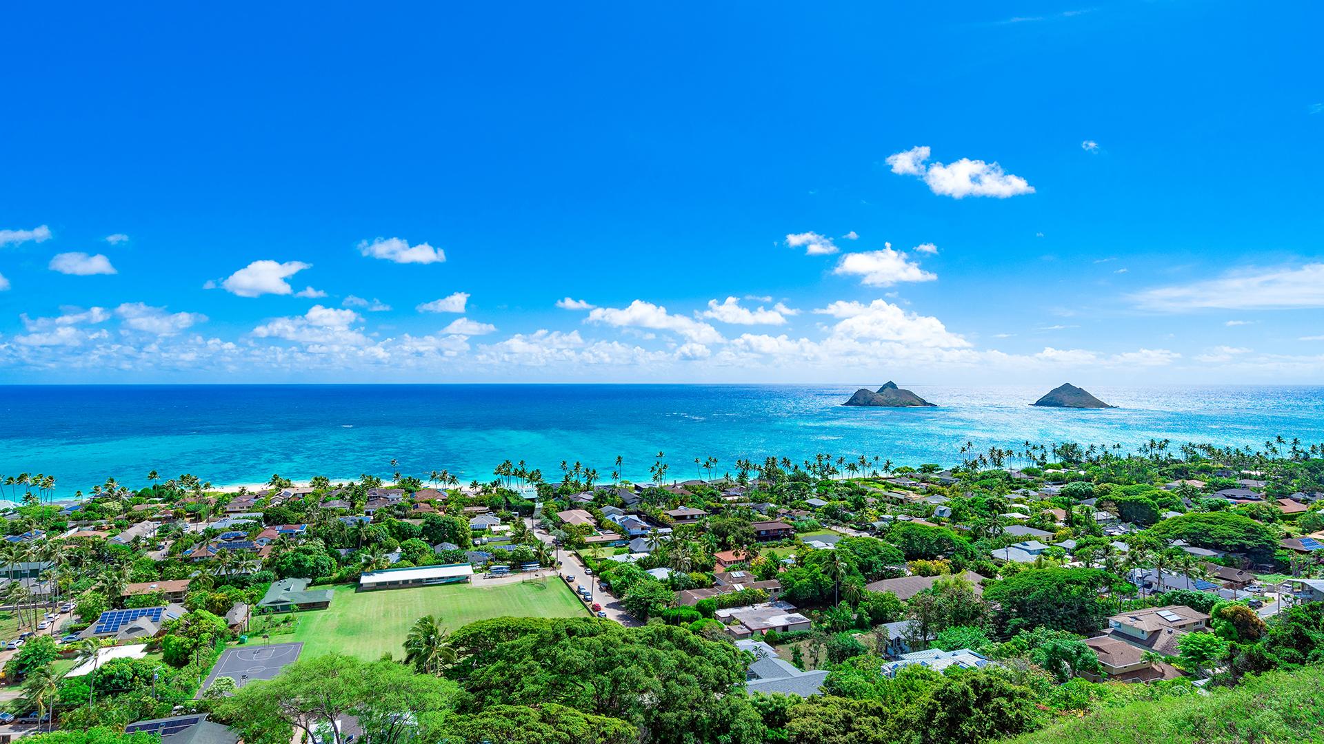 Panoramic view of Kailua, Hawaii, with residential neighbourhoods set in nature along calm, turquoise waters.