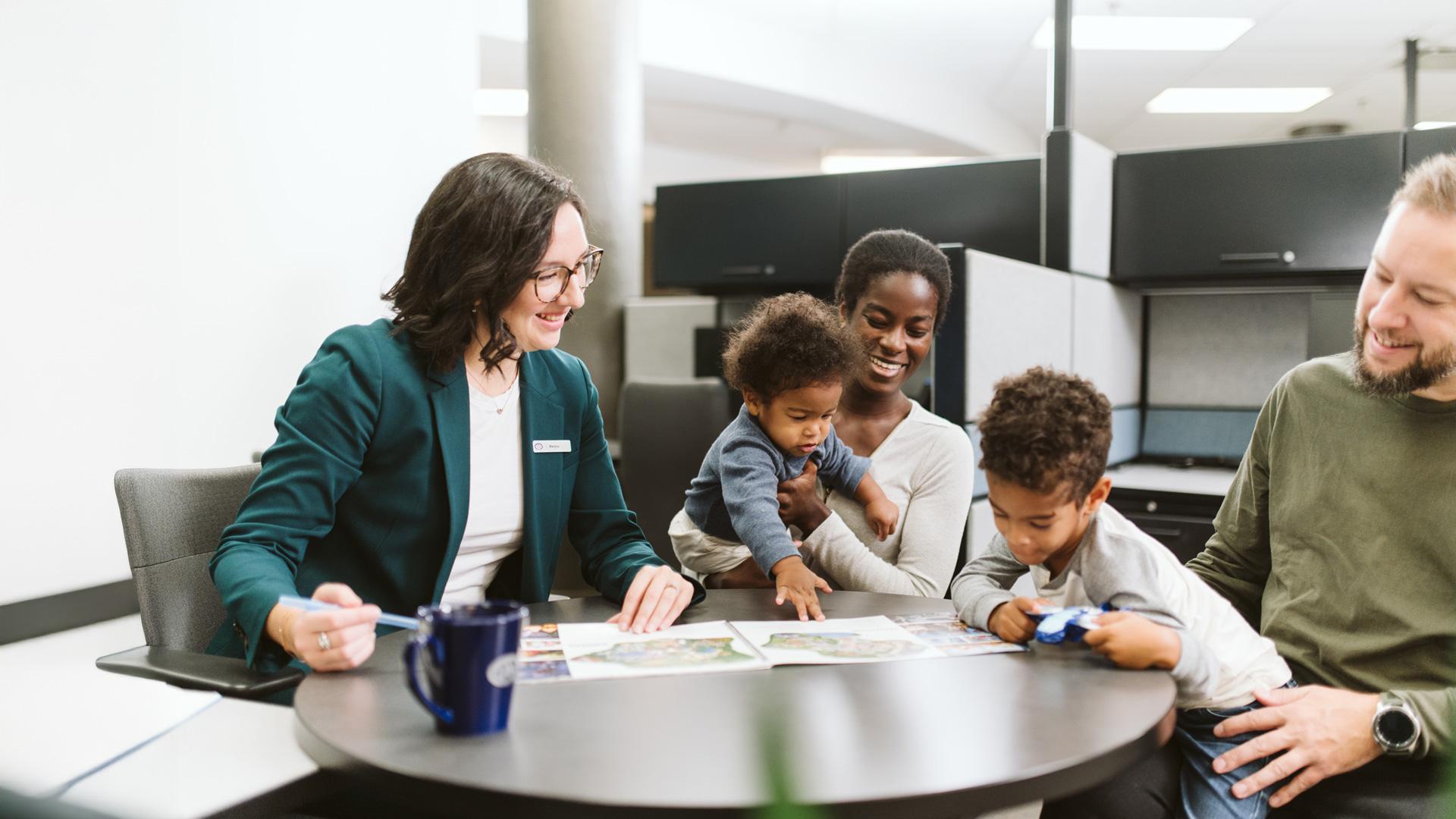 Dans un centre voyage CAA-Québec, une famille est attablée pour discuter planification de voyage avec une conseillère.