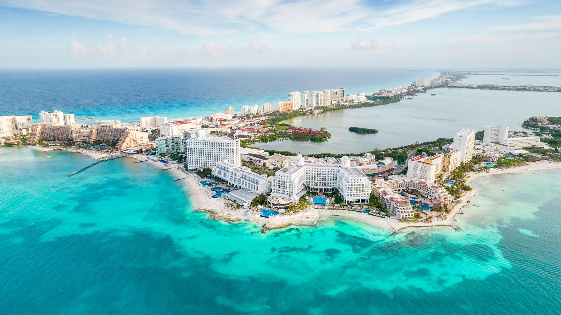 Vue aérienne de la zone hôtelière de Cancún, bordée par la mer turquoise et ses plages de sable blanc.